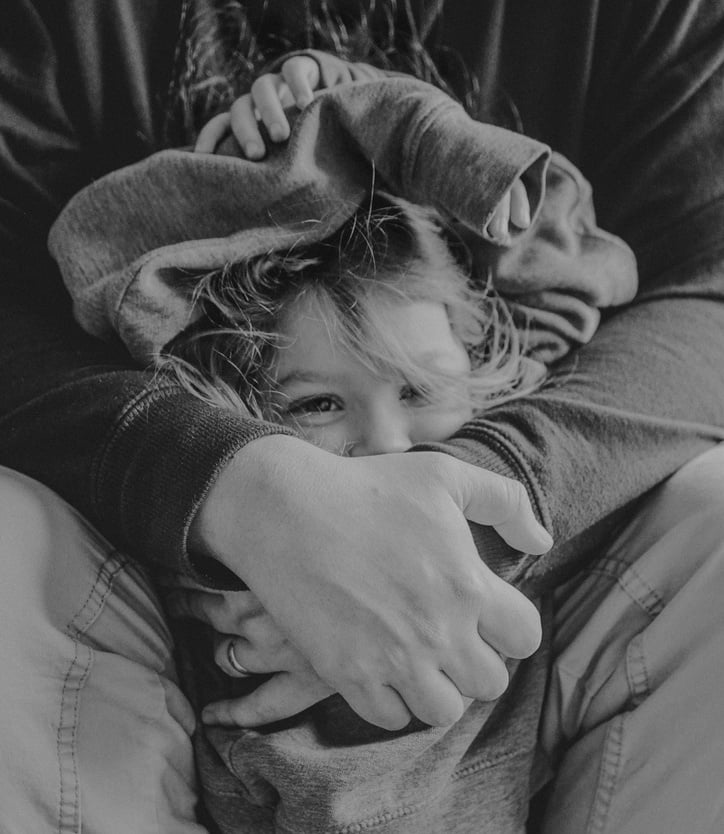 black and white photo of a child hugging their parent