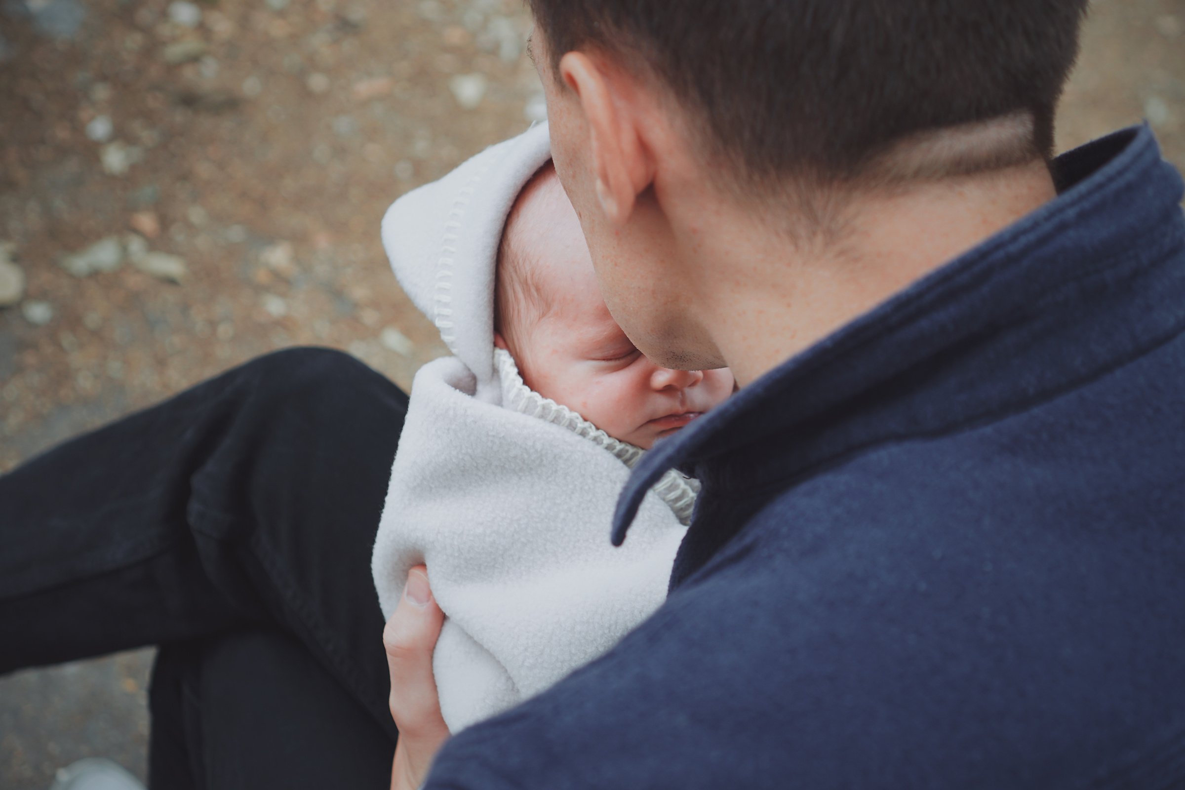 a person holding a baby wrapped in a blanket