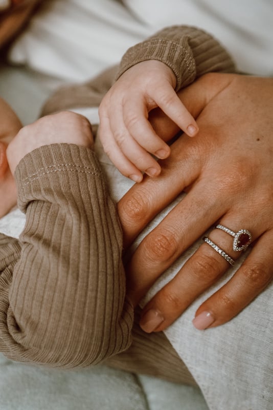 a close up of mothers hands holding a baby's hand