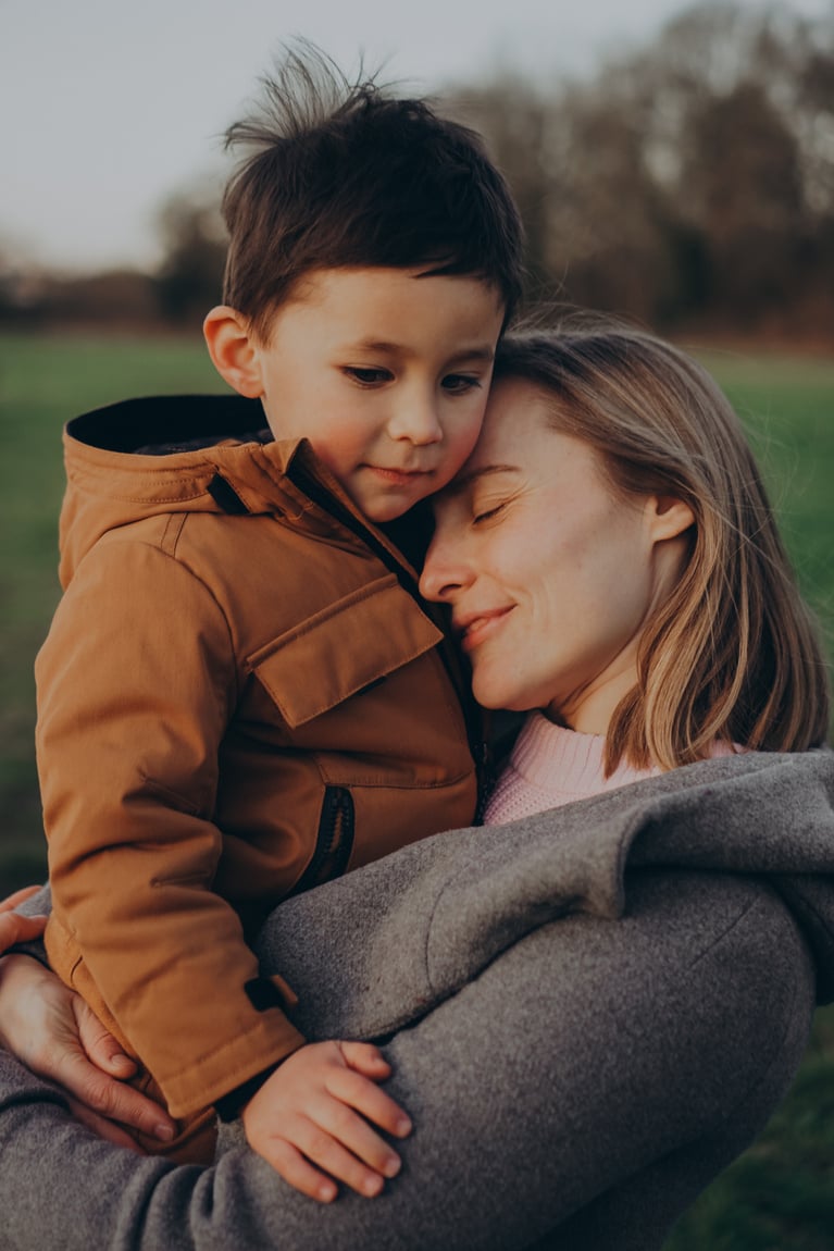 London family photographer mother and son cuddling in a field