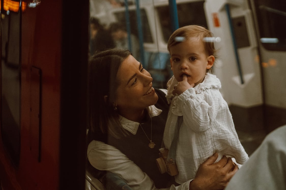 a mother holding a baby on a London Underground tube train